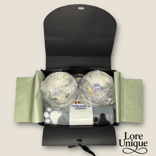 Geschenk Box – Bereit zum Verschenken Geschenkbox mit zwei Bällen, einer Decke und einer Karte, alles sorgfältig verpackt.